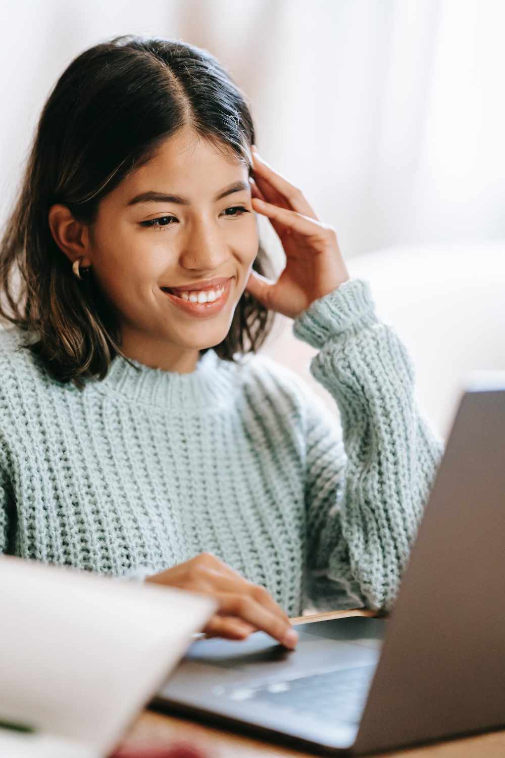 Ragazza seduta davanti al computer segue una lezione online.